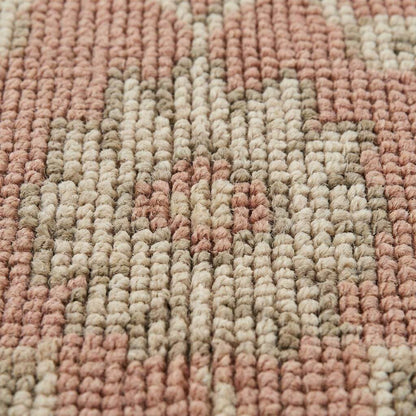 Close up of hand knotted wool rug showing low pile texture, visible knot structure, and natural color variation