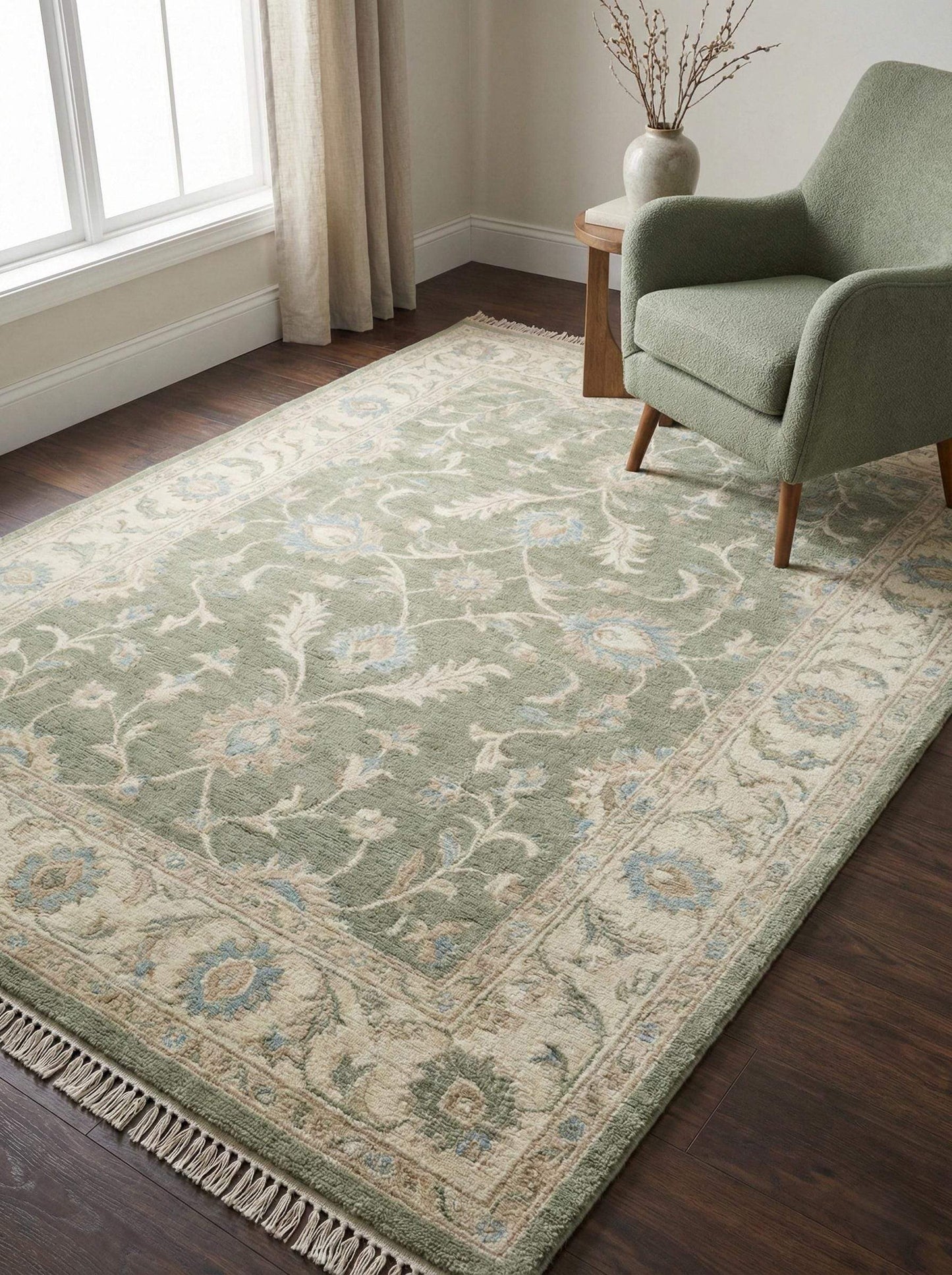 Oushak style hand knotted wool rug in sage green with ivory border and floral details