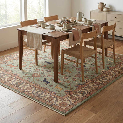 Sage green hand knotted rug with terracotta, cream and rust tones showing natural wool color variation