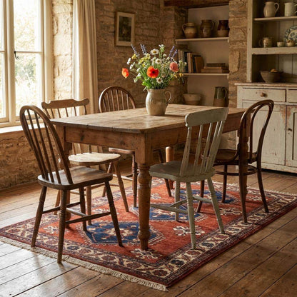 Rust red tribal hand knotted wool rug with geometric Kazak design in living room setting