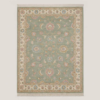 Vintage style sage green Oushak area rug with blush floral accents styled beside a green accent chair __etsy:7832919907
