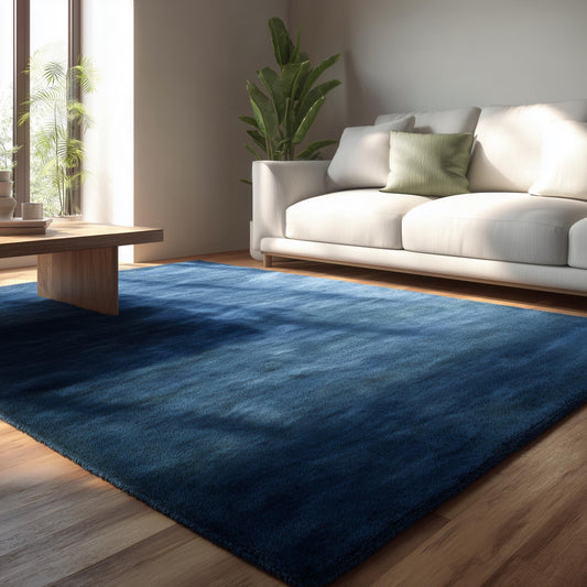 Plush navy blue area rug in a modern living room setting with cream sofa and wood floor – soft textured floor décor accent.