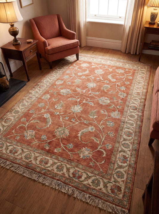 Hand knotted Oushak rug in terracotta with floral vine pattern placed in warm living room setting with wooden flooring __etsy:7970288255