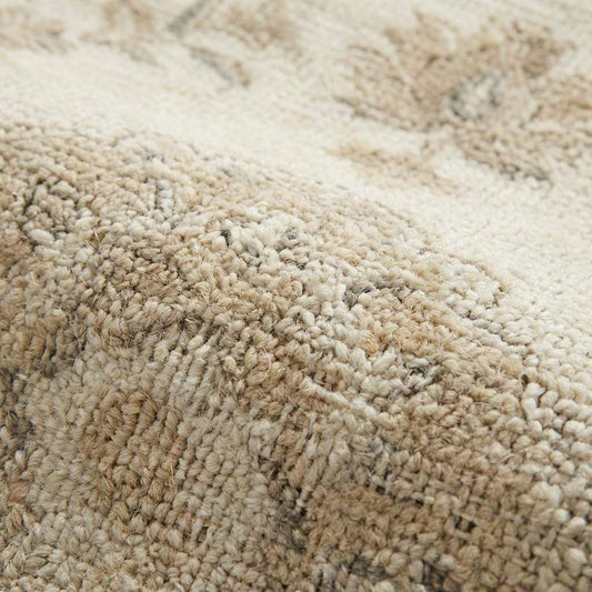 Close up of hand knotted wool rug showing low pile texture, individual knots, and natural wool fibers