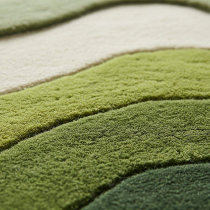 Wave pattern moss rug with green and cream tufted waves resembling rolling hills