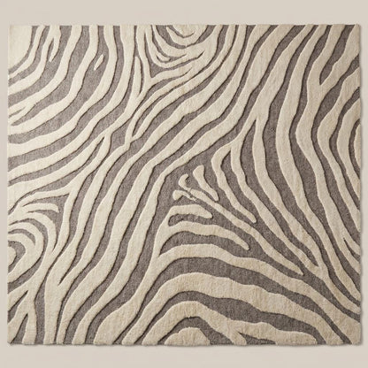 Hand tufted wool area rug with modern abstract zebra pattern in ivory and gray tones