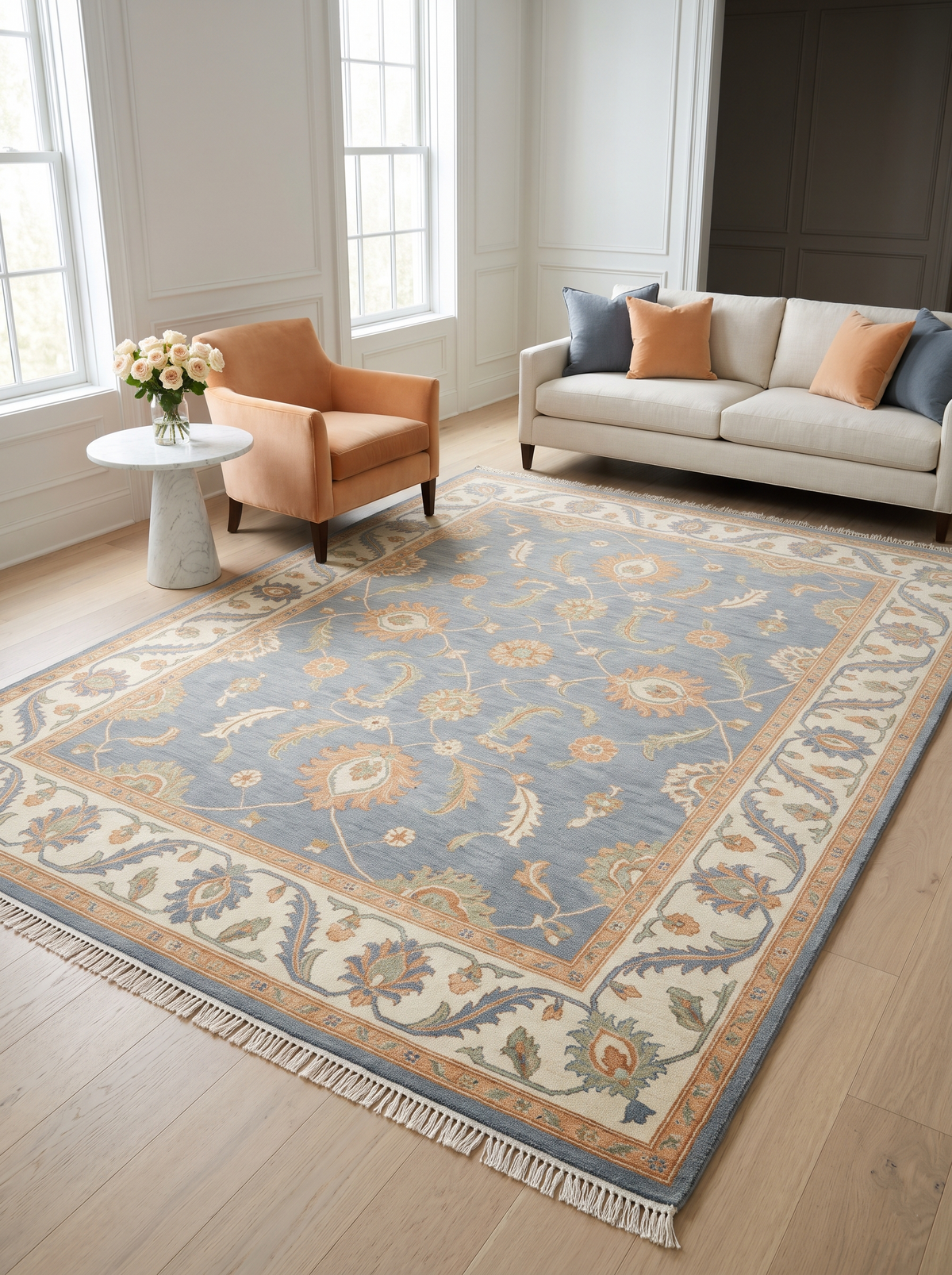 Blue Oushak Rug in slate blue wool with peach and ivory floral motifs, wide ivory vine border and fringe