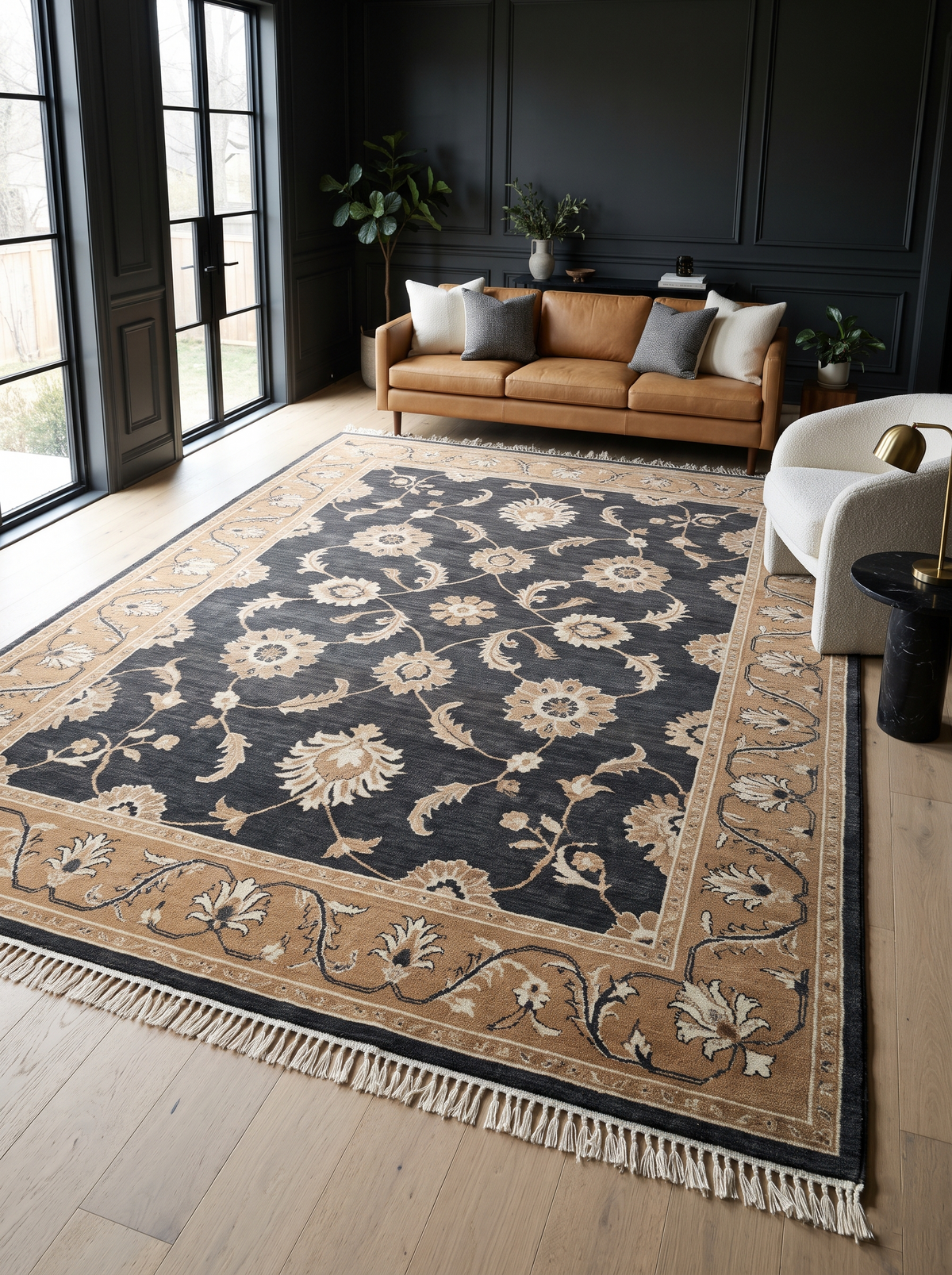 Charcoal Oushak Rug with ivory floral vines on a dark wool field, camel border, and hand-tied fringe