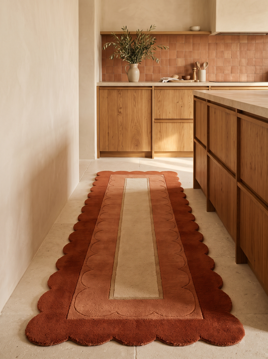 Terracotta Scalloped Runner Rug in rust and terracotta wool, with a sand centre panel and carved scallop borders