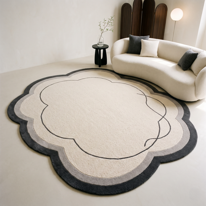 Ivory Cloud Rug in hand-tufted wool with a scalloped flower shape, ivory field, charcoal and grey border and a flowing carved charcoal line