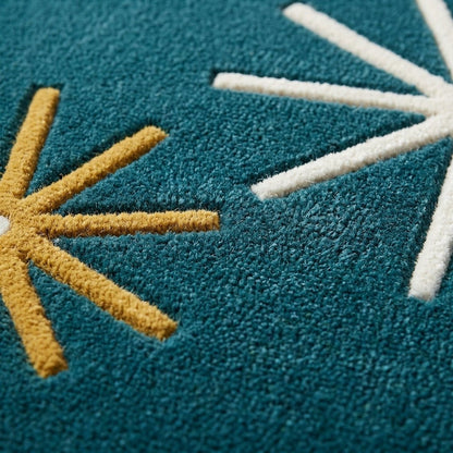 Atomic Starburst Rug in plush deep teal wool with raised ivory and mustard starburst motifs and a carved texture