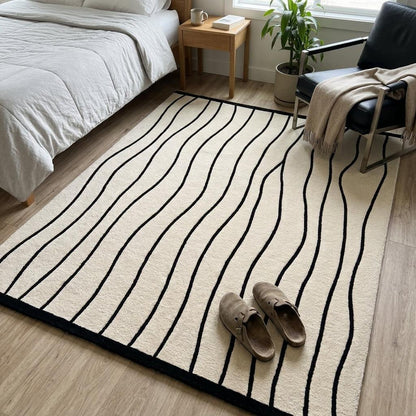 Black and White Wavy Line Rug with flowing black stripes on an ivory ground and a crisp black border