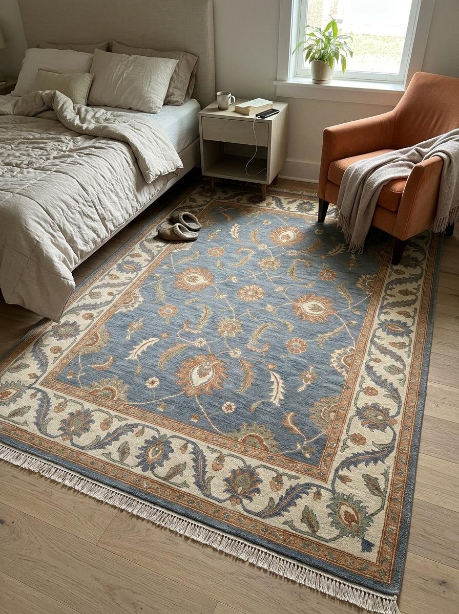 Blue Oushak Rug with slate blue wool field, peach and ivory floral motifs, wide ivory border and fringed ends