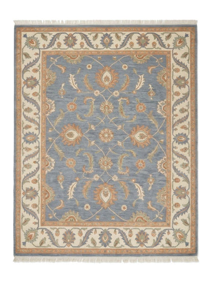 Blue Oushak Rug in slate blue wool with peach and ivory floral motifs, wide ivory border and fringe