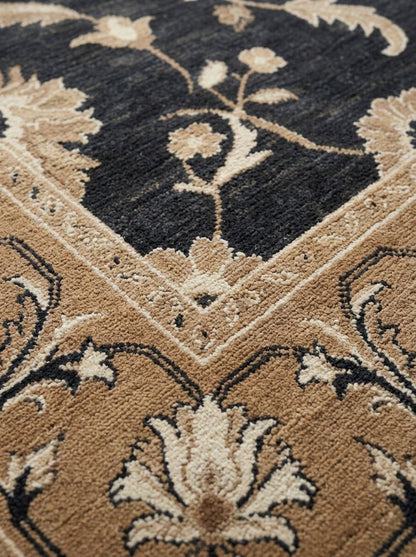 Charcoal Oushak Rug in wool with a dark charcoal field, camel border, and ivory floral vines and palmettes