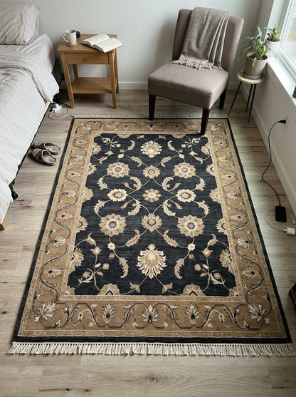 Charcoal Oushak Rug in wool with ivory and camel floral motifs, a wide camel border and fringed edges