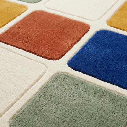 Checkered Rug with plush wool squares in rust, cobalt blue, mustard yellow, sage green and cream, edged with raised carved outlines