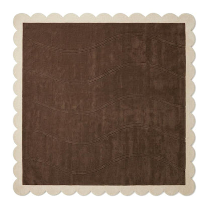 Chocolate Brown Wave rug in plush wool, with carved flowing lines and a cream scalloped border.