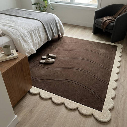 Chocolate Brown Wave wool rug with a plush brown field, carved flowing lines and a cream scalloped border.
