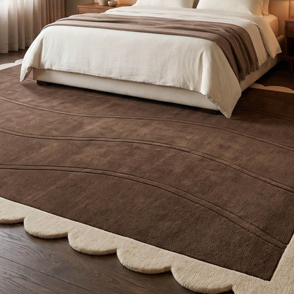 Chocolate Brown Wave wool rug with a plush brown field, carved flowing lines, and a cream scalloped border.