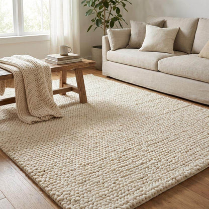 Chunky knit wool rug in neutral tones with thick handwoven texture for cozy boho home decor