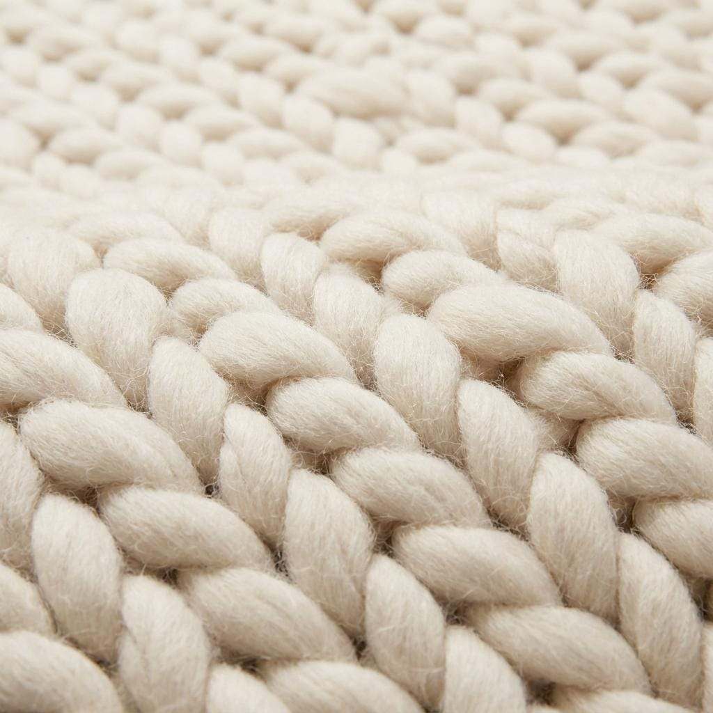 Chunky knit wool rug with thick handwoven yarn in neutral tones for cozy boho home decor