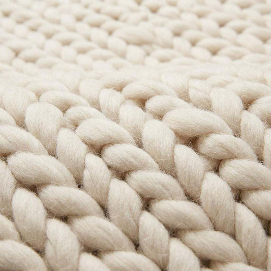 Chunky knit wool rug with thick handwoven yarn in neutral tones for cozy boho home decor