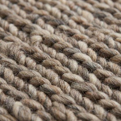 Handwoven chunky wool area rug with thick braided texture in neutral brown tones for modern farmhouse decor
