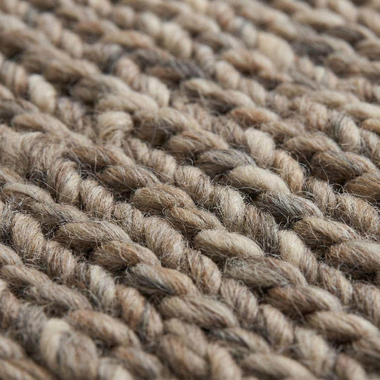 Handwoven chunky wool area rug with thick braided texture in neutral brown tones for modern farmhouse decor