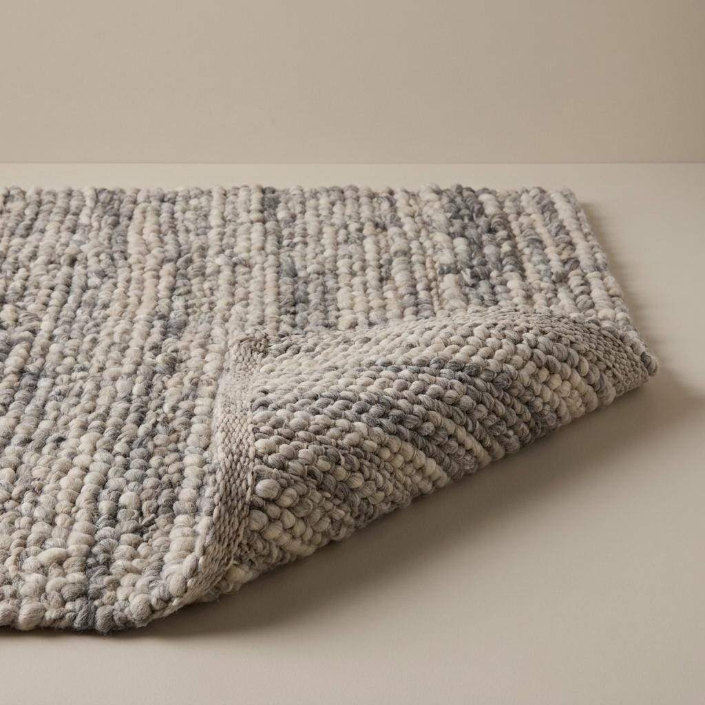 Handwoven chunky wool pebble rug in neutral tones for modern Scandinavian living room decor