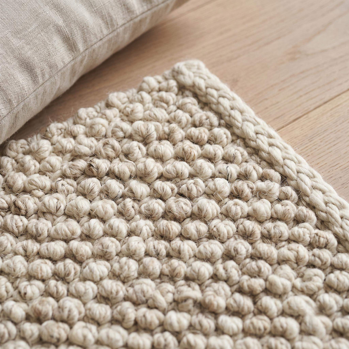 Handwoven chunky wool pebble rug in neutral tones, textured natural wool area rug for cozy minimalist living room decor