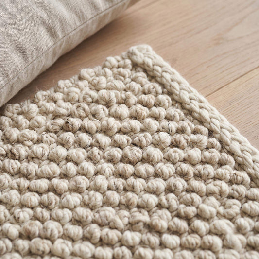 Handwoven chunky wool pebble rug in neutral tones, textured natural wool area rug for cozy minimalist living room decor
