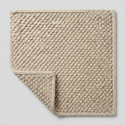Handwoven chunky wool pebble rug with textured natural wool in neutral tones for cozy Scandinavian decor