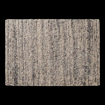 Handwoven chunky wool pebble rug in neutral tones, perfect for modern Scandinavian living room decor