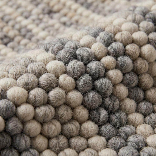 Handwoven chunky wool pebble rug in neutral tones, perfect for modern Scandinavian living rooms