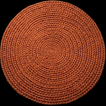 Handwoven chunky wool round rug in terracotta with braided knit texture for cozy modern boho spaces