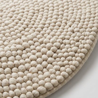 Chunky Wool Rug in cream ivory, with a thick handwoven surface of raised rounded pebble-like loops and a bound edge.