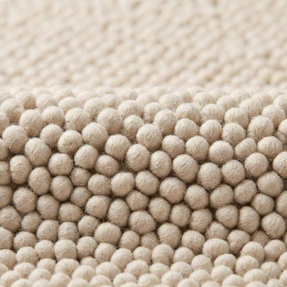 Chunky wool rug with thick handwoven loop pile in neutral cream for cozy minimalist home decor