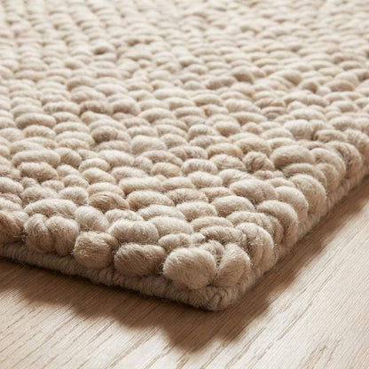 Handmade chunky wool rug with thick knit texture in neutral beige for cozy living room and bedroom decor