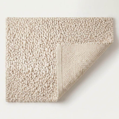 Handmade chunky wool rug with thick textured loops in neutral tones for cozy minimalist home decor