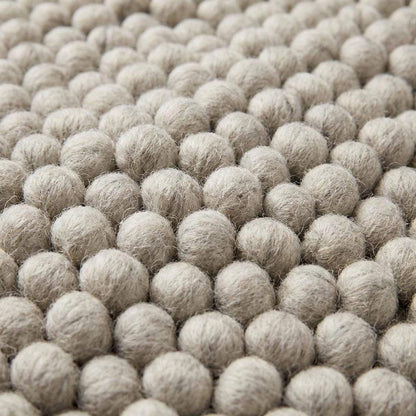 Chunky wool rug with handwoven pebble texture in neutral ivory tones for Scandinavian minimalist living room