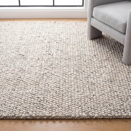 Chunky wool rug with handwoven pebble texture in neutral ivory, ideal for Scandinavian minimalist living rooms.