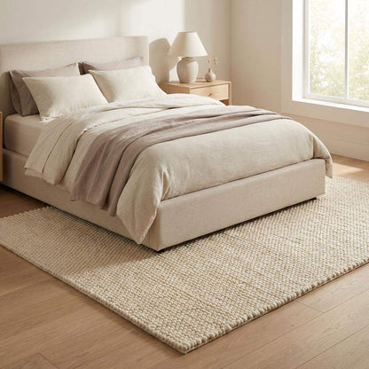 Handmade chunky wool rug in neutral tones, cozy Scandinavian minimalist living room carpet with thick plush texture
