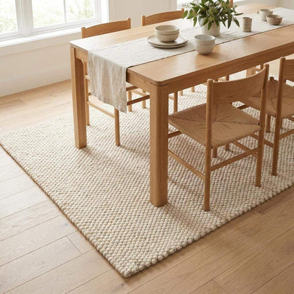 Handwoven chunky wool rug in neutral tones with pebble texture for modern Scandinavian decor