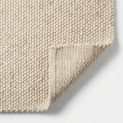 Handwoven chunky wool rug with neutral tones and pebble texture for modern Scandinavian decor