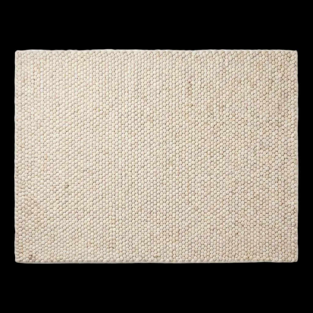 Handwoven chunky wool rug in neutral cream and beige tones with pebble texture, perfect for modern Scandinavian interiors