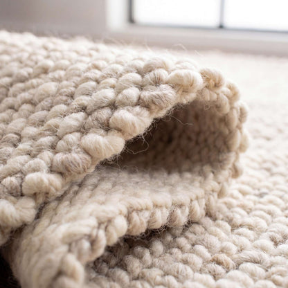 Chunky wool rug with thick handwoven loop pile in neutral tones for cozy minimalist farmhouse and Scandinavian decor