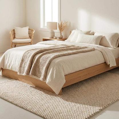 Handwoven chunky wool rug with neutral cream and beige felt balls in modern Scandinavian minimalist living room setting