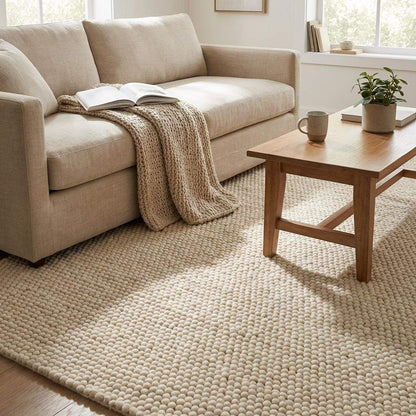 Handmade chunky wool rug with neutral tones in minimalist Scandinavian living room