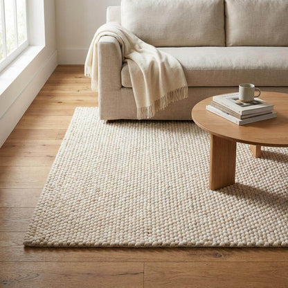 Handwoven chunky wool rug with neutral cream tones and pebble texture for modern Scandinavian decor